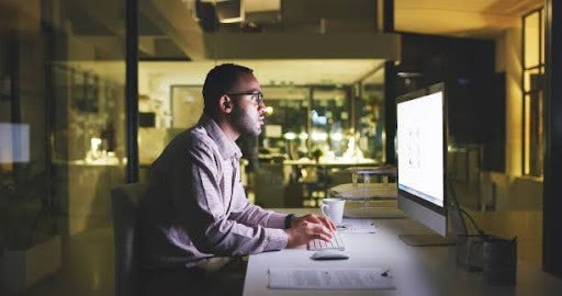 Professional waiting for a website to load on a desktop.